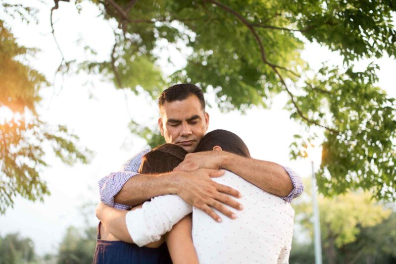 dad hugging two children 614973540